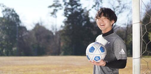 グラウンドでサッカーボールを持つ篠田さん